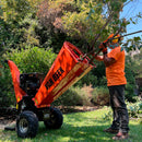 Trabajador de van Beek metiendo unas ramas en la chipeadora a gasolina 15 hp.