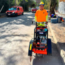 Trabajador utilizando la Cortaconcretos van Beek color naranja en el pavimento durante una obra de construcción.