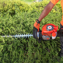 Cortadora de setos podando un arbusto.