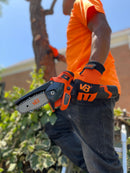 Trabajador con guante van Beek utiliza minisierra eléctrica vBSE4 van Beek naranja para cortes precisos en madera. Ideal para poda, carpintería y bricolaje.