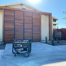 Equipo Tomahawk sobre piso de concreto frente a portón de madera en una casa residencial.